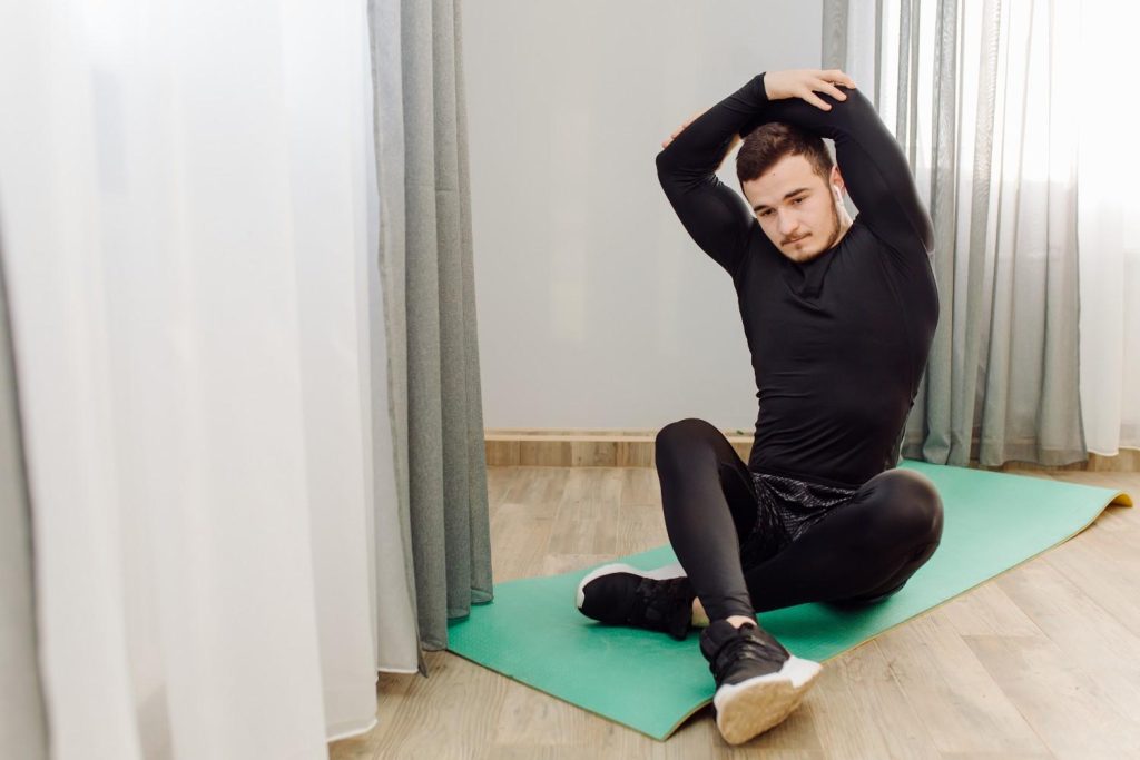 Person demonstrating a seated butterfly stretch to improve hip and inner thigh flexibility