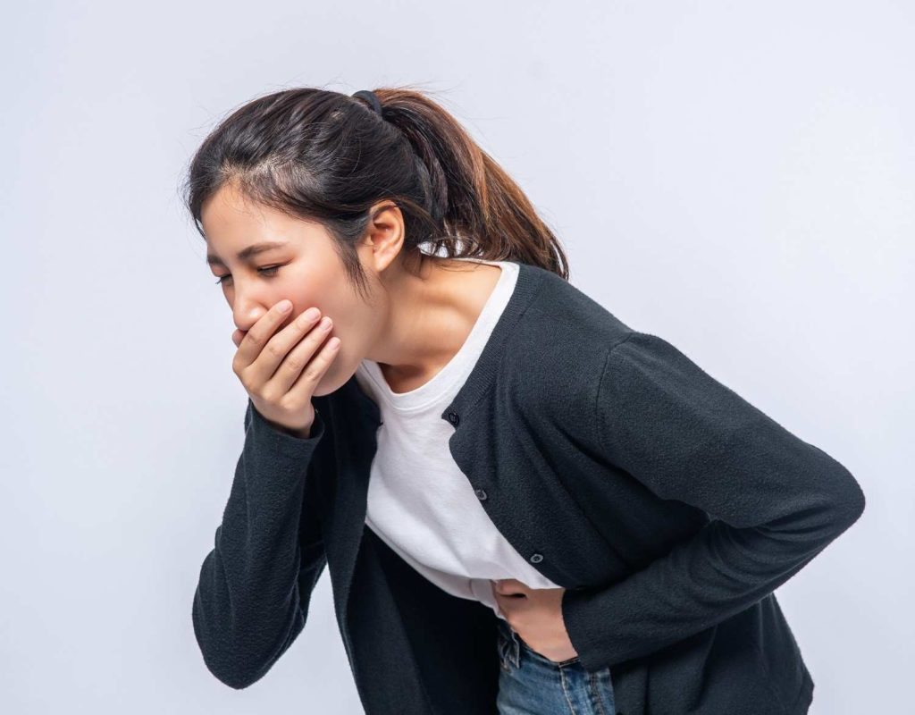 Woman feeling nauseous because of anxiety while holding her stomach