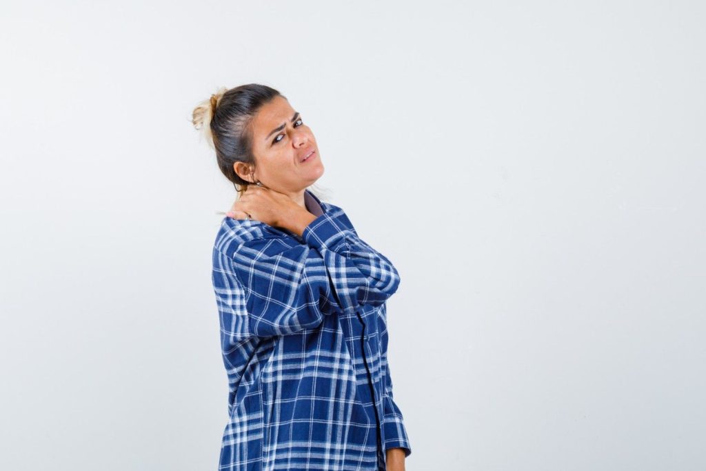Woman experiencing pain around her collarbone and shoulder